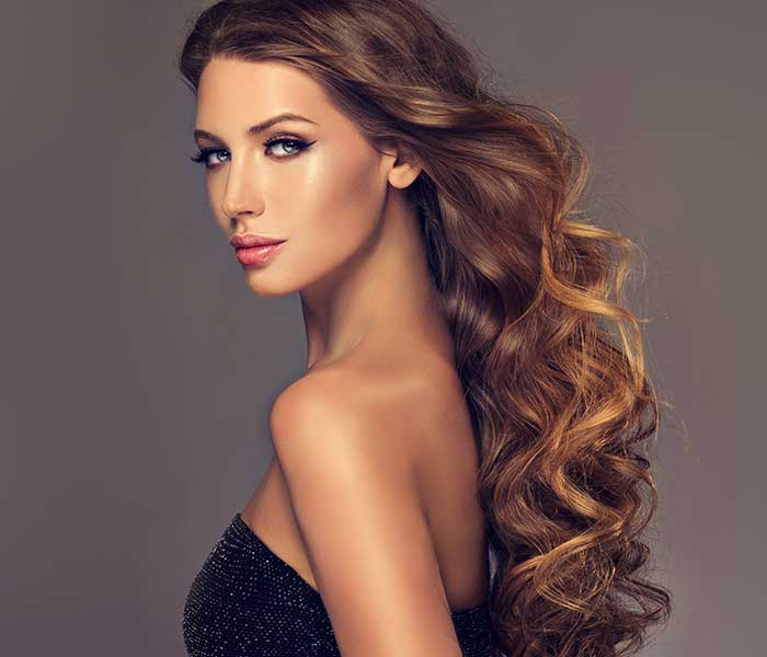 Brown haired woman with voluminous shiny and curly hair